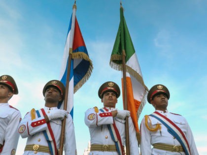 Cuban soldiers of the honour guard carry the Cuban (L) and Irish flag during a wreath-laying ceremony at Revolution Square in Havana, on February 15, 2017. Ireland's President Michael is in Cuba in a four-day official visit. At left, Cuban Foreign Vice Minister Rogelio Sierra. / AFP / ADALBERTO ROQUE …