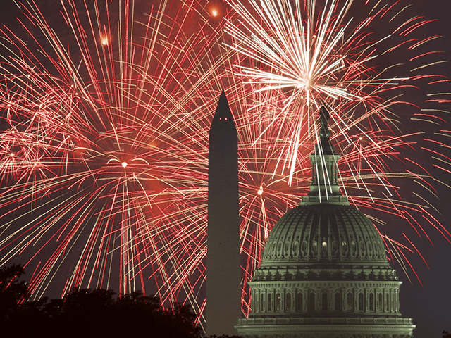 Fireworks explode over the National Mall as the US Capitol (R) and National Monument are s