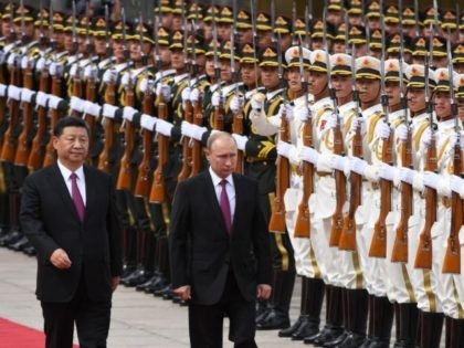 TOPSHOT - Russia's President Vladimir Putin (C) reviews a military honour guard with Chinese President Xi Jinping (L) during a welcoming ceremony outside the Great Hall of the People in Beijing on June 8, 2018. - Putin arrived on June 8 for a state visit to China and will attend …