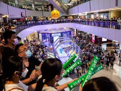 People in a shopping mall come to watch Siobhan Haughey in Hong Kong on July 30, 2021, as she goes on to win a silver medal in the womens 100m freestyle at the Tokyo Olympics. (Photo by ISAAC LAWRENCE / AFP) (Photo by ISAAC LAWRENCE/AFP via Getty Images)