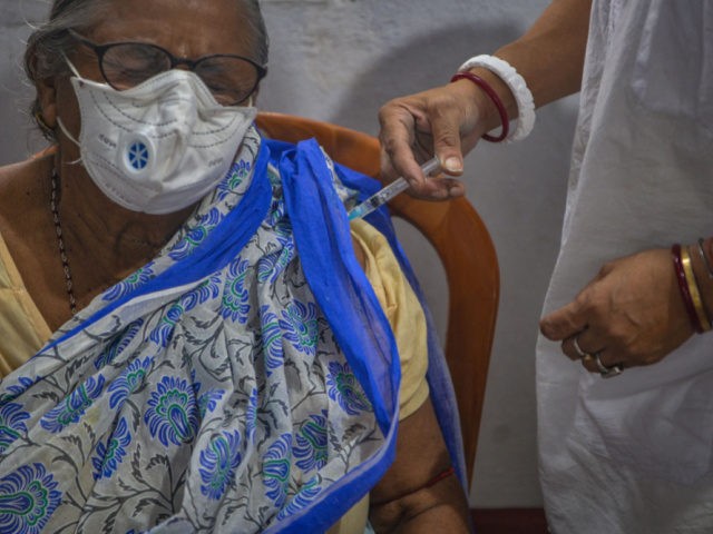 A health worker inoculates an elderly woman with a dose of the Covishield vaccine against the Covid-19 coronavirus at a temporary vaccination camp set up in Siliguri on July 28, 2021. (Photo by Diptendu DUTTA / AFP) (Photo by DIPTENDU DUTTA/AFP via Getty Images)