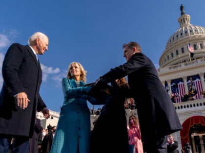 U.S. President Joe Biden turns to kiss first lady Jill Biden as son Hunter takes the Bible
