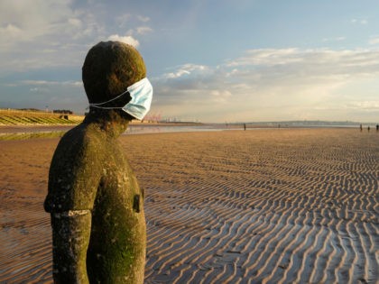 LIVERPOOL, ENGLAND - FEBRUARY 10: One of the 100 life-size body cast statues of 'Another Place' at Crosby beach, created by the artist Sir Antony Gormley wears a Covid-19, coronavirus face mask during the pandemic lockdown Crosby on February 10, 2021 in Liverpool, England. (Photo by Christopher Furlong/Getty Images)