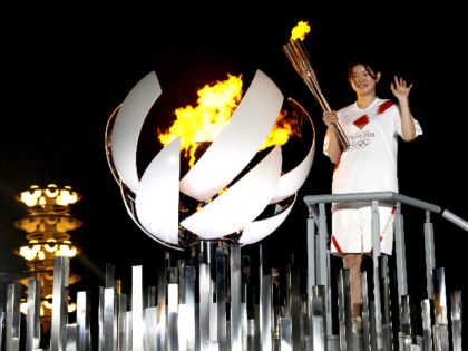 TOKYO, JAPAN - JULY 23: Gold medalist Ayaka Takahashi of Team Japan lights the cauldron at Yume no Ohashi Bridge after the Opening Ceremony of the Tokyo 2020 Olympic Games at Olympic Stadium on July 23, 2021 in Tokyo, Japan. (Photo by Rob Carr/Getty Images)