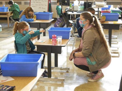 A student and teacher interact in the classroom during Portland Public Schools first day of hybrid instruction at Jason Lee Elementary School on Thursday, April 1, 2021 in Portland, Ore. (Tom McKenzie/AP Images for Portland Public Schools)