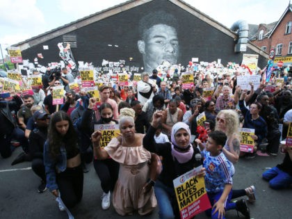 Anti-racism protestors demonstrate by a mural of England forward Marcus Rashford after it was defaced on July 13, 2021 in Manchester, northwest England. - The mural was vandalised on July 12 after the England football team lost the UEFA Euro 2020 final. (Photo by Lindsey Parnaby / AFP) (Photo by …