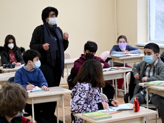 Schoolchildren wearing face masks listen to a teacher at a school in Tbilisi on February 15, 2021, as in-person classes resume in Georgian schools amid the ongoing coronavirus disease pandemic. (Photo by Vano Shlamov / AFP) (Photo by VANO SHLAMOV/AFP via Getty Images)