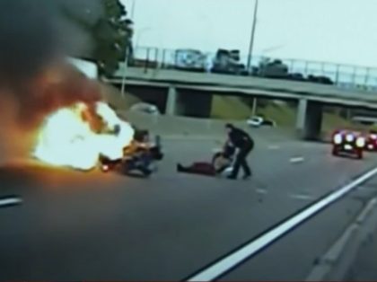 Harper Woods, MI public safety officer pulls man from burning vehicle. Screenshot via YouT