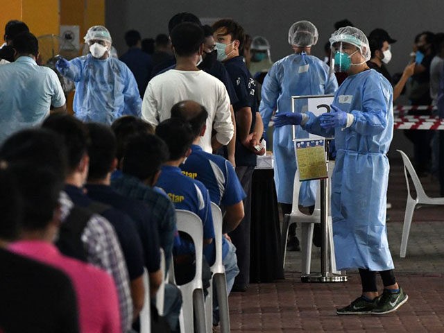 Essential workers wait to take a nasal swab test to detect the COVID-19 novel coronavirus before returning to work in Singapore on June 10, 2020. (Photo by Roslan RAHMAN / AFP) (Photo by ROSLAN RAHMAN/AFP via Getty Images)