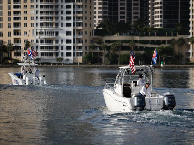 Boats with Cuban and US flags part of a Cuban support flotilla depart from Bayside in downtown Miami for Cuba, on July 23, 2021. - The flotilla plans to stay in international waters off Cuba to let island residents know they have support in Florida. (Photo by Eva Marie UZCATEGUI …