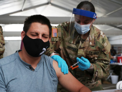 NORTH MIAMI, FLORIDA - MARCH 10: A U.S. Army soldier from the 2nd Armored Brigade Combat Team, 1st Infantry Division, immunizes Max Pietro with the Johnson and Johnson COVID-19 vaccine at the Miami Dade College North Campus on March 10, 2021 in North Miami, Florida. The soldiers deployed to assist …