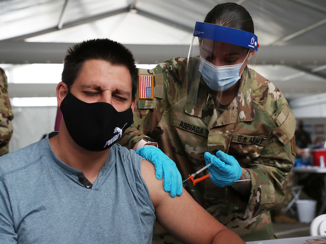 NORTH MIAMI, FLORIDA - MARCH 10: A U.S. Army soldier from the 2nd Armored Brigade Combat Team, 1st Infantry Division, immunizes Max Pietro with the Johnson and Johnson COVID-19 vaccine at the Miami Dade College North Campus on March 10, 2021 in North Miami, Florida. The soldiers deployed to assist the Federal Emergency Management Agency at the state-run, federally-supported COVID-19 Community Vaccination Center. (Photo by Joe Raedle/Getty Images)