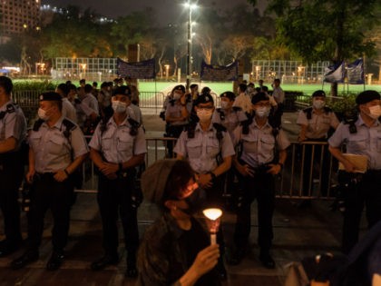 HONG KONG, CHINA - JUNE 04: A woman holds candle as she walks in front of the Victoria Par