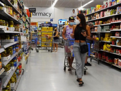 People wearing protective masks shop in a Walmart store on May 18, 2021 in Hallandale Beach, Florida. Walmart announced that customers who are fully vaccinated against Covid-19 will not need to wear a mask in its stores, unless one is required by state or local laws. The announcement came after …