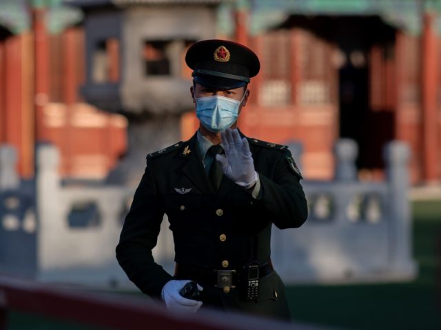 A soldier wearing face masks gestures outside the Forbidden City in Beijing on October 22, 2020, on the eve of the 70th anniversary of Chinas entry into the 1950-53 Korean War. (Photo by NICOLAS ASFOURI / AFP) (Photo by NICOLAS ASFOURI/AFP via Getty Images)