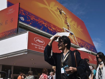 People walk by the Palais des festivals at the 72nd international film festival, Cannes, southern France, Monday, May 13, 2019. The Cannes film festival runs from May 14th until May 25th 2019. (AP Photo/Petros Giannakouris)