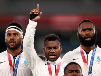 CHOFU, JAPAN - JULY 28: Jerry Tuwai of Team Fiji sings on the podium with his team mates after receiving their gold medals following victory in the Rugby Sevens Men's Gold Medal match between New Zealand and Fiji on day five of the Tokyo 2020 Olympic Games at Tokyo Stadium …