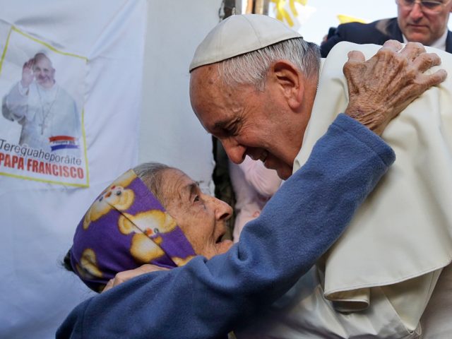 Pope Francis is greeted by a Catholic faithful during his visit to the Banado Norte neighborhood in Asuncion, on July 12, 2015. Pope Francis visited the poorest neighborhood of Paraguay before ending his Latin American tour. (Photo by Gregorio BORGIA / POOL / AFP) (Photo by GREGORIO BORGIA/POOL/AFP via Getty …