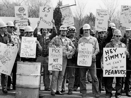 A group of metal trade workers from the Portsmouth Naval Shipyard gather outside town meeting in Portsmouth, New Hampshire, on Wednesday, April 26, 1979 to protest the ceiling President Carter has put on the wages of federal employees. They argued the ceiling will make no dent on inflation and will …
