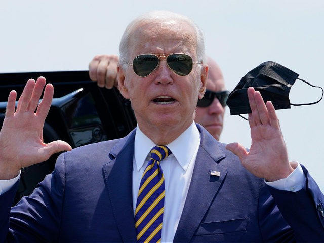 President Joe Biden holds a mask as he responds to a question as he arrives at Lehigh Valley International Airport in Allentown, Pa., Wednesday, July 28, 2021. Biden is in the area to visit the Lehigh Valley operations facility for Mack Trucks and advocate for government investments and clean energy …
