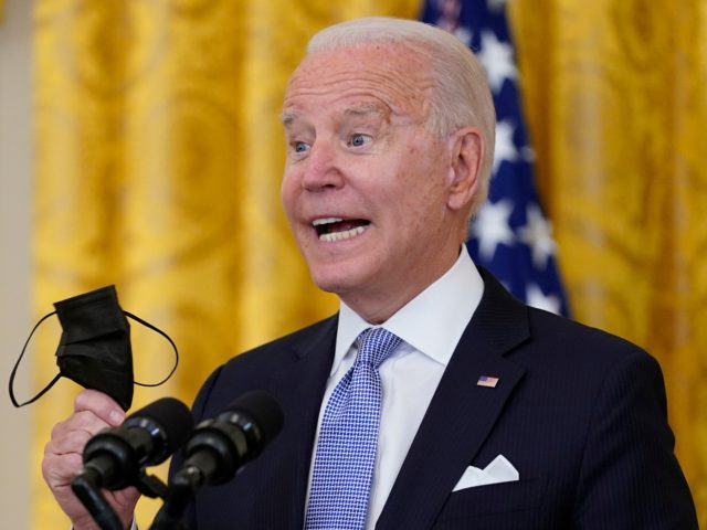 President Joe Biden holds his face mask as he speaks in the East Room of the White House in Washington, Thursday, July 29, 2021. (AP Photo/Susan Walsh)