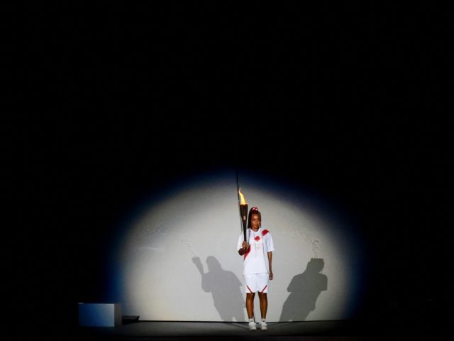 Japanese tennis player Naomi Osaka holds the Olympic Torch before lighting the flame of hope in the Olympic Cauldron during the opening ceremony of the Tokyo 2020 Olympic Games, at the Olympic Stadium, in Tokyo, on July 23, 2021. (Photo by Franck FIFE / AFP) (Photo by FRANCK FIFE/AFP via …
