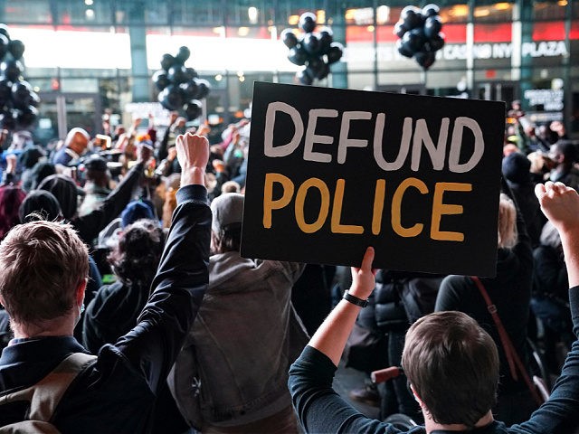 FILE - In this Oct. 14, 2020, file photo a protester holds a sign that reads "Defund Police" during a rally for the late George Floyd outside Barclays Center in New York. Some police organizations and Republican politicians are blaming Democrats and last year's defund the police effort for a …