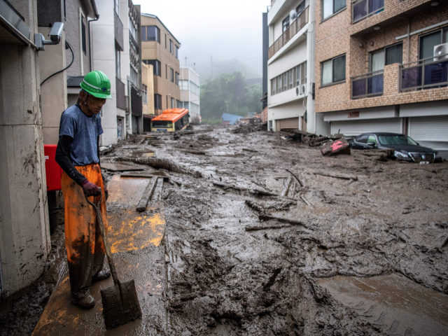 A rescue worker removes mud and debris at the scene of a landslide following days of heavy rain in Atami in Shizuoka Prefecture on July 3, 2021. (Photo by Charly TRIBALLEAU / AFP) (Photo by CHARLY TRIBALLEAU/AFP via Getty Images)