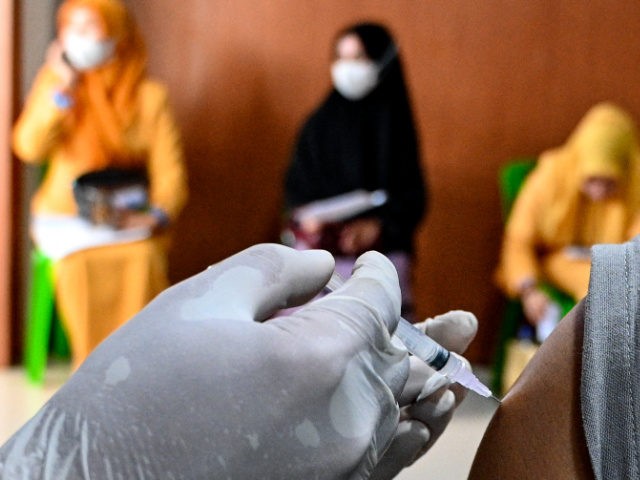 A health worker administers a dose of the Sinovac Covid-19 coronavirus vaccine at a convention hall building in Banda Aceh on July 26, 2021. (Photo by CHAIDEER MAHYUDDIN / AFP) (Photo by CHAIDEER MAHYUDDIN/AFP via Getty Images)