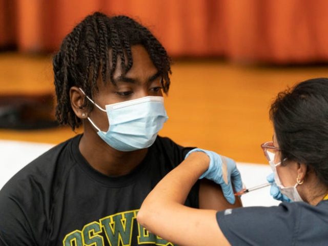 Zhaequan Brown, 19, gets the Pfizer coronavirus vaccine at Lehman High School, Tuesday, Ju
