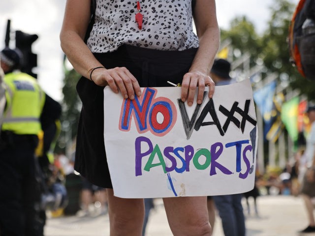 Anti-vaccination protesters, including one holding a placard against coronavirus vaccine p