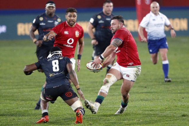 British and Irish Lions prop Rory Sutherland (R) passes the ball during a tour match again