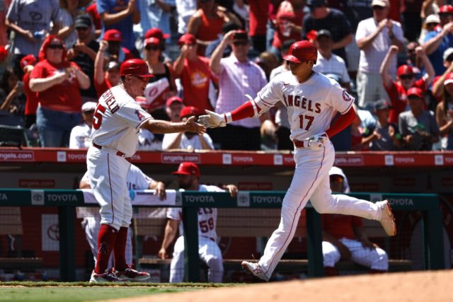 Shohei Ohtani celebrates with Los Angeles Angels teammate Brian Butterfield after hitting