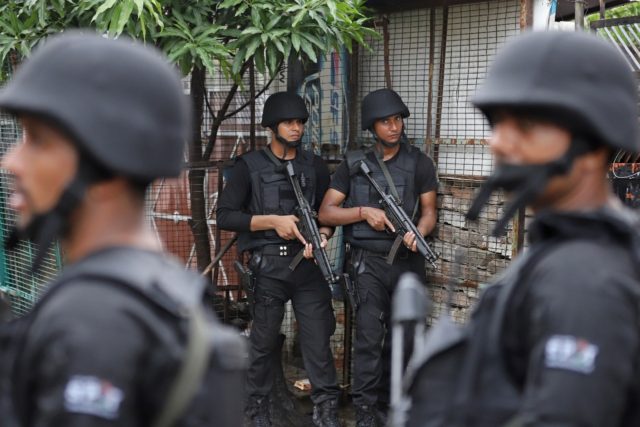 Members of India's Anti-Terrorism Squad (ATS) stand guard outside a house in Lucknow, the