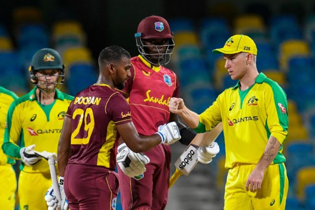 Nicholas Pooran and Alzarri Joseph of West Indies are congratulated by Adam Zampa (right)