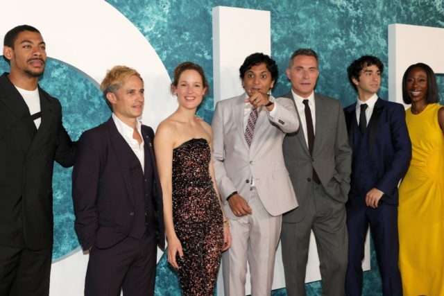 The cast of "Old," which was written and directed by M. Night Shyamalan (center), attends