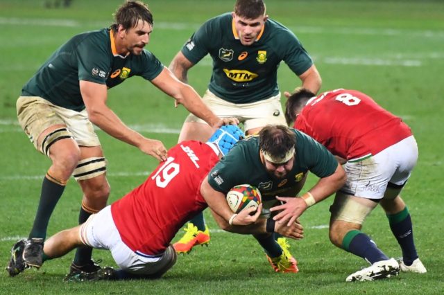 South Africa prop Frans Malherbe (C) is tackled by British and Irish Lions loose forwards
