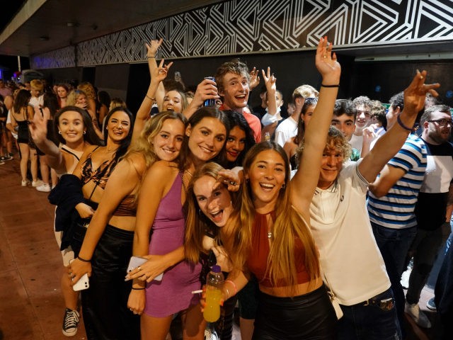 BRIGHTON, ENGLAND - JULY 18: Clubbers queue around the block at a few minutes to midnight waiting for Covid-19 restrictions to be dropped and for Pryzm nightclub to open its doors once more on July 18, 2021 in Brighton, England. At a minute past midnight, England dropped most of its …
