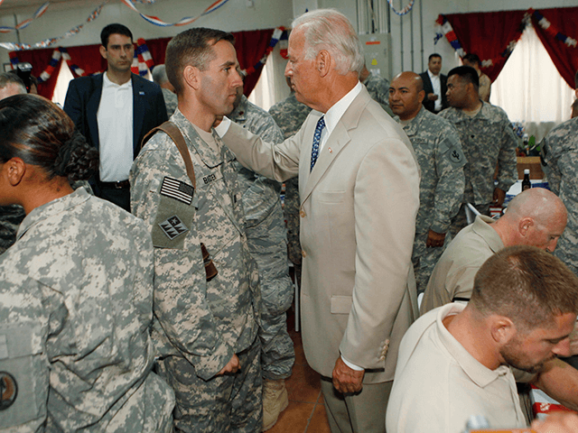 U.S. Vice President Joe Biden, centre right, talks with his son, U.S. Army Capt. Beau Biden, centre left, at Camp Victory on the outskirts of Baghdad, Iraq, Saturday, July 4, 2009. Biden celebrated the Fourth of July with his son and other American troops in Iraq on Saturday, a day after warning Iraqi leaders that U.S. assistance will be jeopardized if the country reverts to ethnic and sectarian violence. Biden began Independence Day by greeting more than 200 U.S. soldiers who were becoming American citizens at a naturalization ceremony in a marble domed hall at one of Saddam Hussein's palaces at Camp Victory, the U.S. military headquarters on the outskirts of Baghdad. (AP Photo/ Khalid Mohammed, Pool)