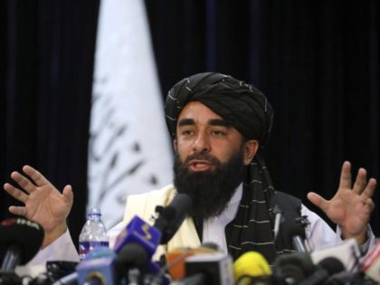 In front of a Taliban flag, Taliban spokesman Zabihullah Mujahid speaks at at his first news conference, in Kabul, Afghanistan, Tuesday, Aug. 17, 2021. For years, Mujahid had been a shadowy figure issuing statements on behalf of the militants. Mujahid vowed Tuesday that the Taliban would respect women's rights, forgive …