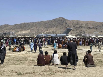 FILE - In this Monday, Aug. 16, 2021 file photo hundreds of people gather near a U.S. Air Force C-17 transport plane along the perimeter at the international airport in Kabul, Afghanistan. Hundreds of Western nationals and Afghan workers have been flown to safety since the Taliban reasserted control over …