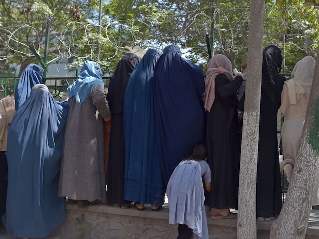 Internally displaced Afghan women, who fled from the northern province due to battle between Taliban and Afghan security forces, gather to receive free food being distributed by Shiite men at Shahr-e-Naw Park in Kabul on August 13, 2021. (Photo by WAKIL KOHSAR / AFP) (Photo by WAKIL KOHSAR/AFP via Getty …