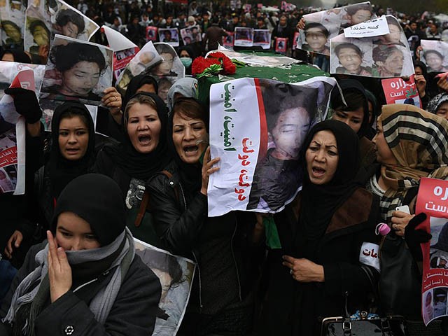 Afghan protesters carry a coffin containing a decapitated body of one of seven Shiite Muslim Hazaras, including four men, two women and one child, during a demonstration in Kabul on November 11, 2015. Thousands of protesters marched coffins containing the decapitated bodies of seven Shiite Hazaras through the Afghan capital Kabul on November 11 to demand justice for the gruesome beheadings, which prompted fears of sectarian bloodshed in the war-torn country. Demonstrators gathered in the rain in west Kabul and marched towards the city centre, chanting death slogans to the Taliban and the Islamic State group while demanding justice and protection from the government. AFP PHOTO / SHAH Marai (Photo credit should read SHAH MARAI/AFP via Getty Images)