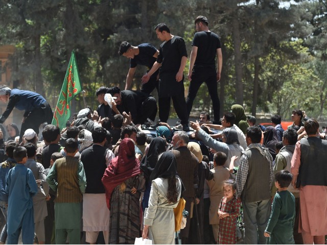 Internally displaced Afghan people, who fled from the northern province due to battle between Taliban and Afghan security forces, gather to receive free food being distributed by Shiite men at Shahr-e-Naw Park in Kabul on August 13, 2021. (Photo by WAKIL KOHSAR / AFP) (Photo by WAKIL KOHSAR/AFP via Getty Images)