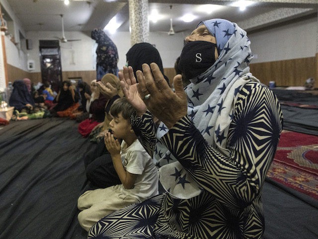 KABUL, AFGANISTAN - AUGUST 13 : Displaced Afghan women and children from Kunduz pray at a mosque that is sheltering them on August 13, 2021 in Kabul, Afghanistan. Tensions are high as the Taliban advance on the capital city after taking Herat and the country's second-largest city Kandahar. (Photo by …