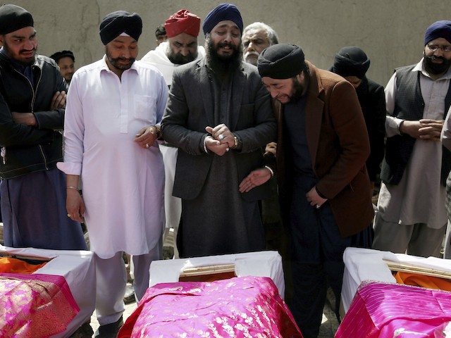 FILE- in this Thursday, March 26, 2020 file photo, Afghan Sikh men mourn their beloved ones during a funeral procession for those who were killed on Wednesday by a lone Islamic State gunman, rampaged through a Sikh house of worship, in Kabul, Afghanistan. (AP Photo/Tamana Sarwary, file)