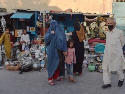 A burqa clad Afghan woman looks for items to buy at a shop displaying used household items for sale at a market area in Kabul on August 25, 2021, which were earlier purchased from the people who faced financial adversities and those who fled the country after Taliban's military takeover …