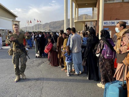 Afghan people queue up to board a U S military aircraft to leave Afghanistan, at the military airport in Kabul on August 19, 2021 after Taliban's military takeover of Afghanistan. (Photo by Shakib RAHMANI / AFP) (Photo by SHAKIB RAHMANI/AFP via Getty Images)