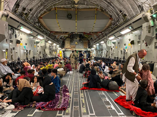 TOPSHOT - Afghan people sit inside a U S military aircraft to leave Afghanistan, at the military airport in Kabul on August 19, 2021 after Taliban's military takeover of Afghanistan. (Photo by Shakib RAHMANI / AFP) (Photo by SHAKIB RAHMANI/AFP via Getty Images)
