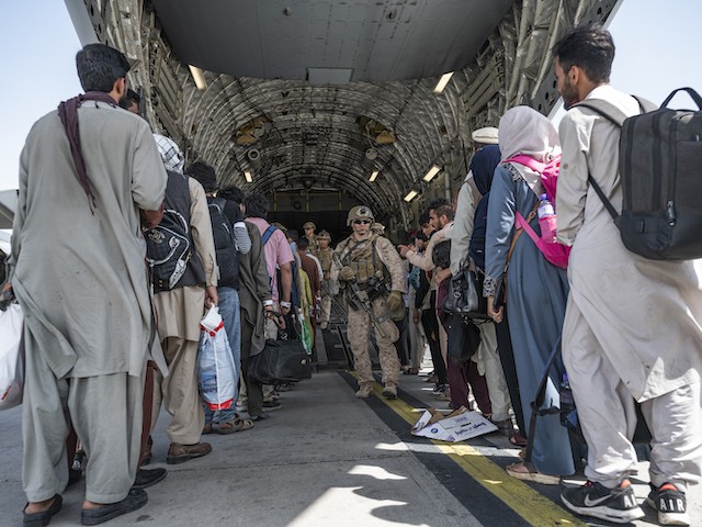 U.S. Airmen and U.S. Marines guide qualified evacuees aboard a U.S. Air Force C-17 Globemaster III in support of the Afghanistan evacuation at Hamid Karzai International Airport (HKIA), Afghanistan, Aug. 21, 2021. The Department of Defense is committed to supporting the U.S. State Department in the departure of U.S. and allied civilian personnel from Afghanistan and to evacuate Afghan allies to safety. (U.S. Air Force photo by Senior Airman Brennen Lege)